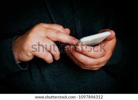 Close up of male person's hands with mobile phone.