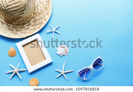 Beach hat and picture frame with starfish,Shell on blue table In the summer Asia,copy space,Top view,minimal style