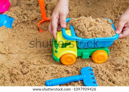 child playing in the sandbox on a summer day