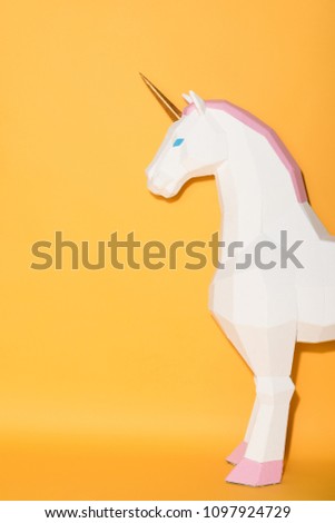 partial view of decorative unicorn standing on yellow background 