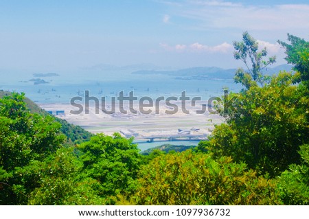 This photo is taken on the hill side of the Ngong Ping Trail, Lautau Island. On the trail, we can oversee the airport. It is between the blue sea and sunny sky.