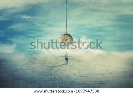Surreal view as a man walking on a pavement road and a suspended clock on his back hanging from the sky. The importance of time in the modern world. Time travel concept. Royalty-Free Stock Photo #1097947538