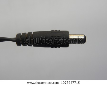 Black color male connector of power plug adapter on white background