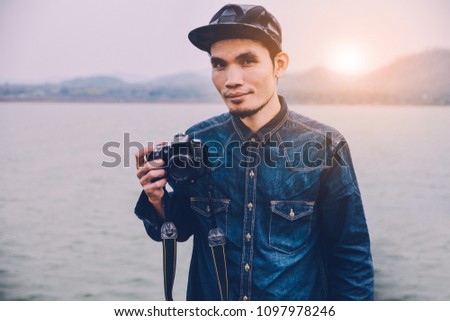 Man holding Camera on hand at river vintage