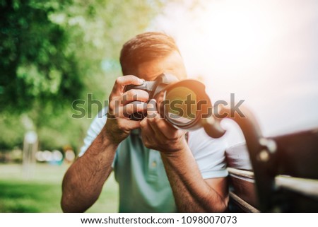 Close-up image of photographer outdoors. Lens flare.