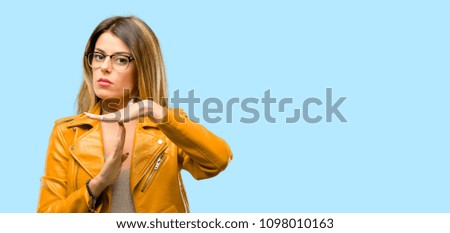 Beautiful young woman serious making a time out gesture with hands