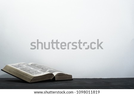 Bible on the dark table. Beautiful white background