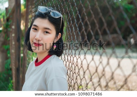 Portrait of beautiful asian chic girl pose for take a picture on the fence,Lifestyle of teen thailand people,Modern woman happy concept