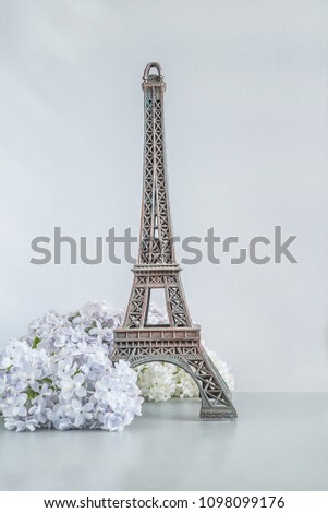 Eiffel tower and lilac flowers on white background