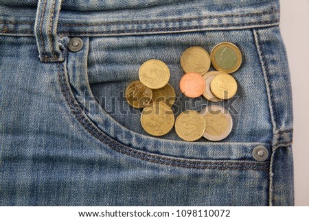 Euro coin with a denomination of twenty euro cents in the pocket of old worn denim jeans Last money. Concept photo. 10, 20, 2, 50, 1 euro coin