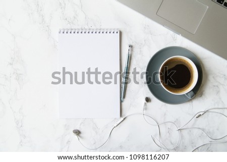 Workplace flatlay with notebook, laptop and coffee cup on marble table