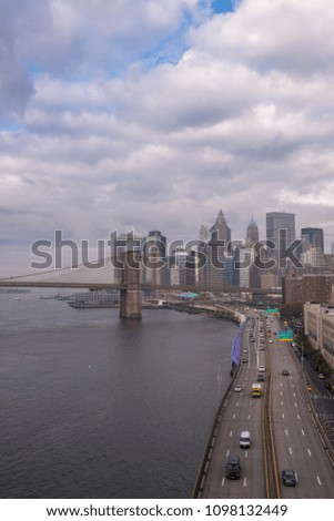 Downtown Manhattan skyline and Brooklyn Bridge with  FDR drive on moody morning  