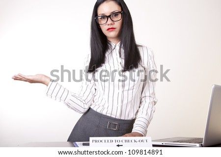 Portrait of a young attractive female receptionist with a sign proceed to check out.