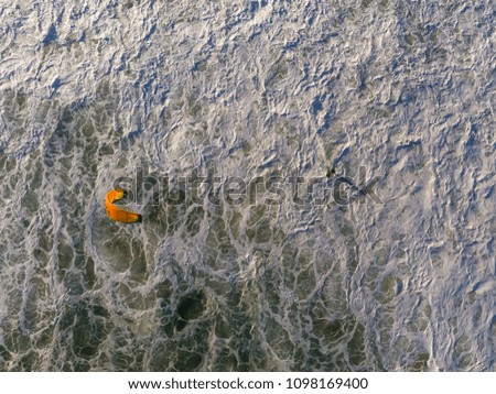 Top view Drone photo of wind surfer riding on beach in Barra da Tijuca, Rio de Janeiro, Brazil. Waves crashing with whitewash, creating patterns on the sea
