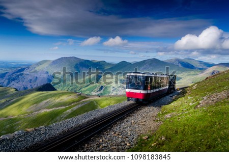 Train going up to the summit of mount Snowdon in Wales UK Royalty-Free Stock Photo #1098183845