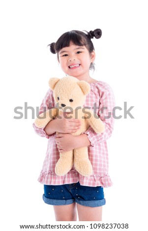 Little asian girl holding teddy bear and smiles over white background