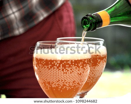 Background of hand of man fulfill beer on two glasses for drinking with friends