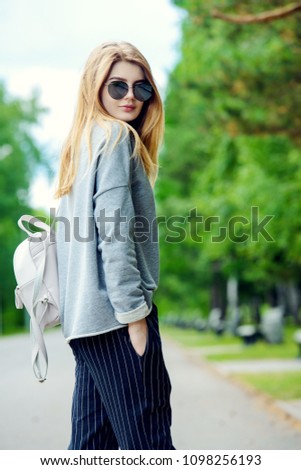 Teen style. Modern young girl with long blonde hair posing outdoor. Beauty, fashion. 