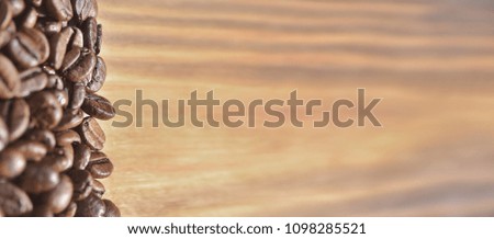 Coffee beans on a light brown wooden background.