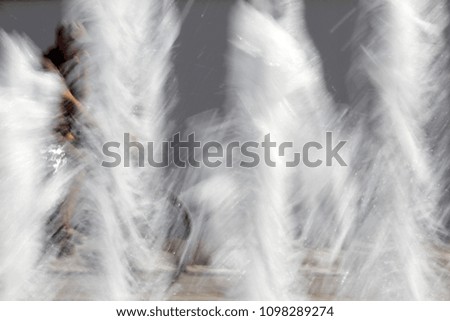 Motion blur picture of children ride bikes. Motion blurred photo with riders. Motion picture of kids ride a bikes in a park background. Blurred wallpaper with people do sports. Copy space for text