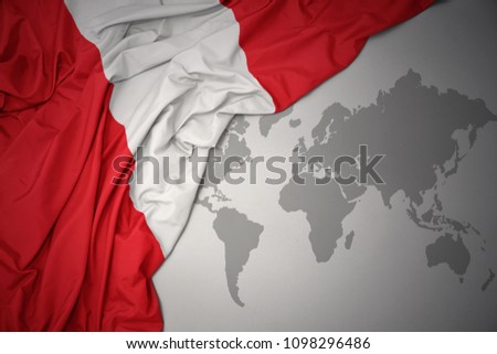 waving colorful national flag of peru on a gray world map background.