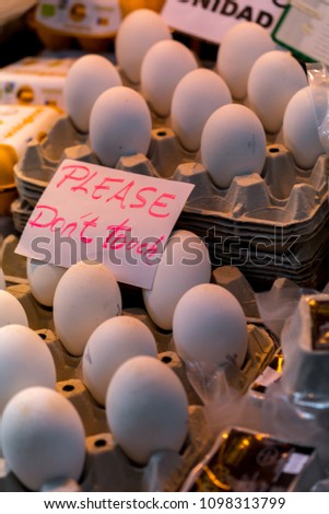 Goose eggs sold in a market bazaar in Spain, with tourist taking pictures.