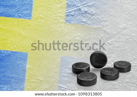 Image of a Swedish flag on ice and hockey pucks. Concept, hockey, background