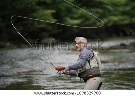 Fisherman fly-fishing in river Royalty-Free Stock Photo #1098329900