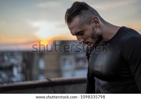 There is no success without sweat. Young handsome man training hard and sweating. Man doing sports outside on the bridge. Outdoors recreation, stretching and training fit body Royalty-Free Stock Photo #1098335798