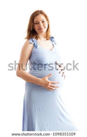 Pregnant woman wearing a long blue dress over white background in studio photo