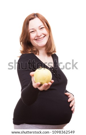 Studio photo of pregnant woman with an apple in hands isolated over white background