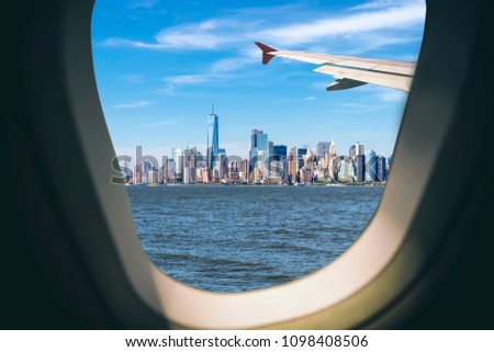 Aerial view of New York cityscape through airplane window while approaching to airport