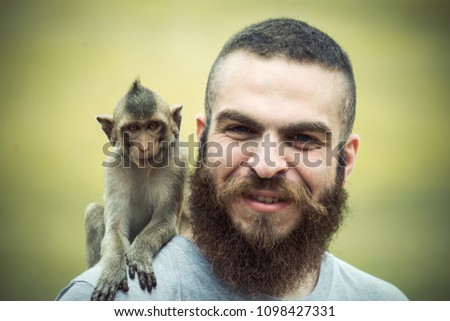 This picture shows a man with a monkey on his shoulder. 