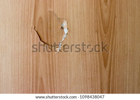 A broken wooden door and a hole in the door close up Royalty-Free Stock Photo #1098438047