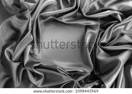 Smooth elegant dark grey or silver silk or satin luxury cloth fabric texture, abstract background design. Copy space