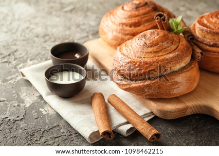Sweet cinnamon buns on wooden board