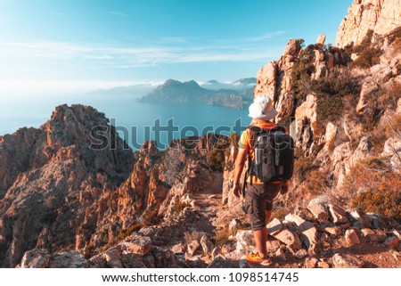 Hiker looking at the view at Calanques de Piana in Corsica, France Royalty-Free Stock Photo #1098514745