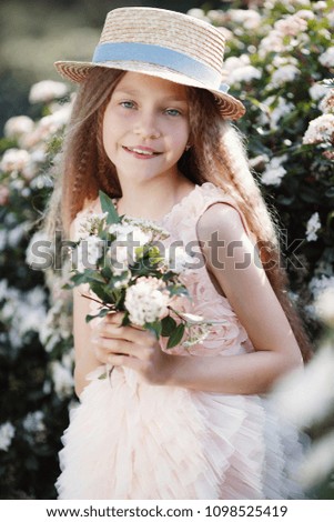 beautiful child girl in blooming flower garden