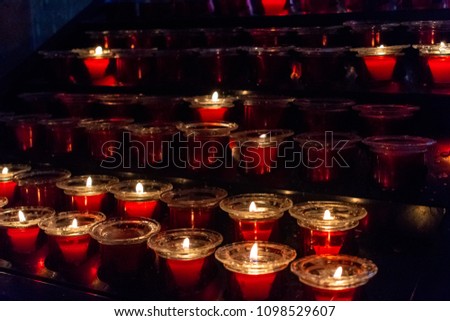 a number of burning candles in the Church