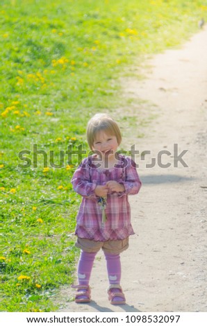 a child near the field of dandelion in the Park on a Sunny summer day with the keys to the house in his hands