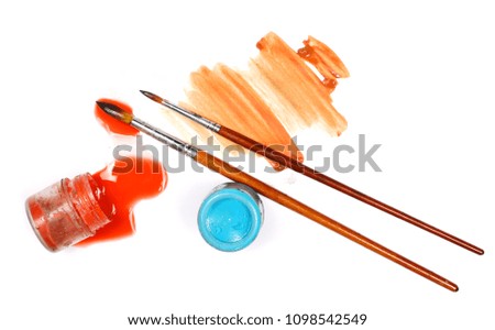 Spilled red watercolor with bottle and paintbrush isolated on white background, top view