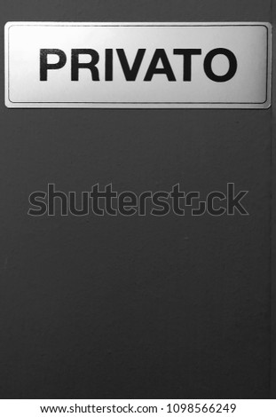 A wooden black wall with a sign sign with the word - privato. Private property