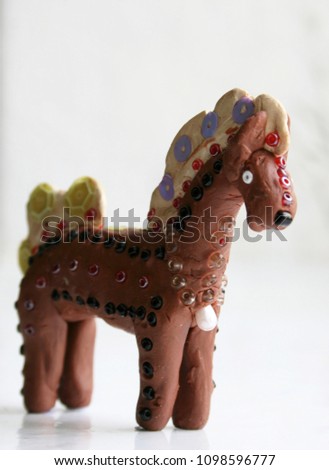 Figurine of plasticine toy horse. Shallow depth of field.