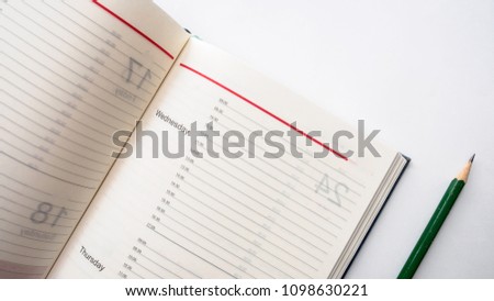 Schedule book daily planner with pencil on white background