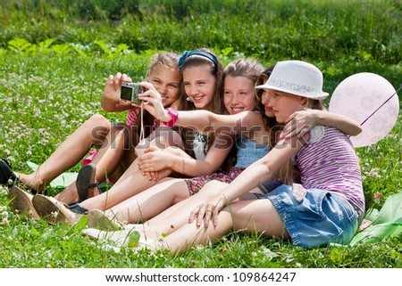 beautiful girls taking picture on grass in city park outdoors