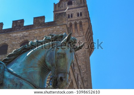 Extreme close up of the Equestrian Monument of Cosimo I with Palazzo Vecchio at background in Piazza della Signoria. Florence, Italy.