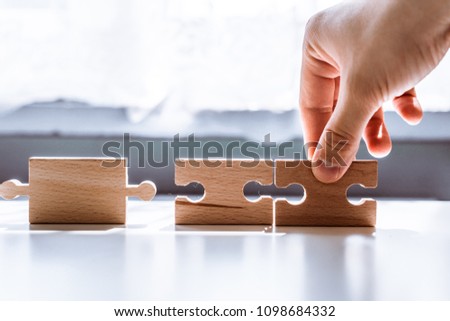 The man points to the same two incompatible jigsaw puzzles. The concept of misunderstanding, non-conforming elements, mutually exclusive statements. Royalty-Free Stock Photo #1098684332