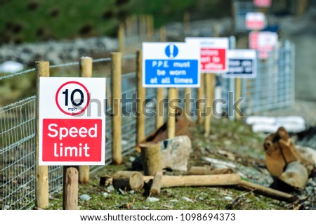 Signs along the path of a construction site including Speed Limit, PPE must be worn etc.