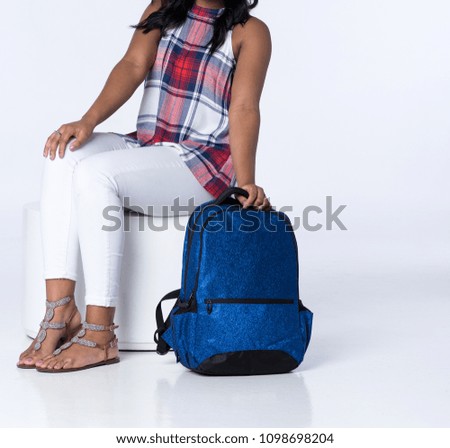 Young Stylish Girl Seated with a Blue Backpack