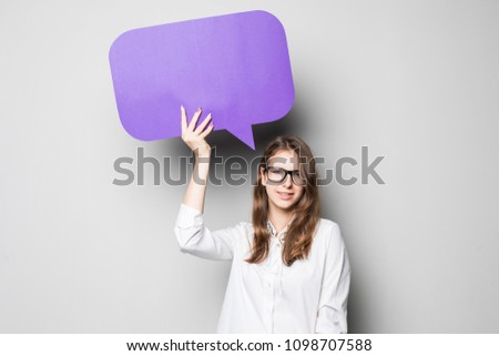 Business woman holding a speech bubble on gray